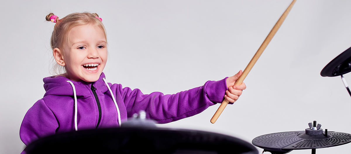 Girl happily playing the drums