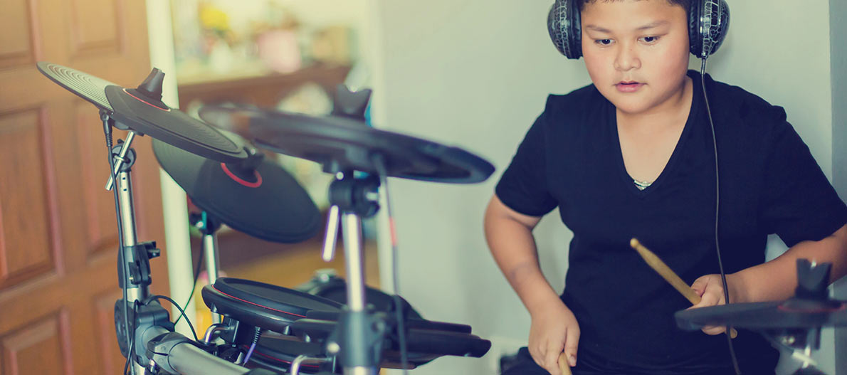 A boy playing electric drum kit