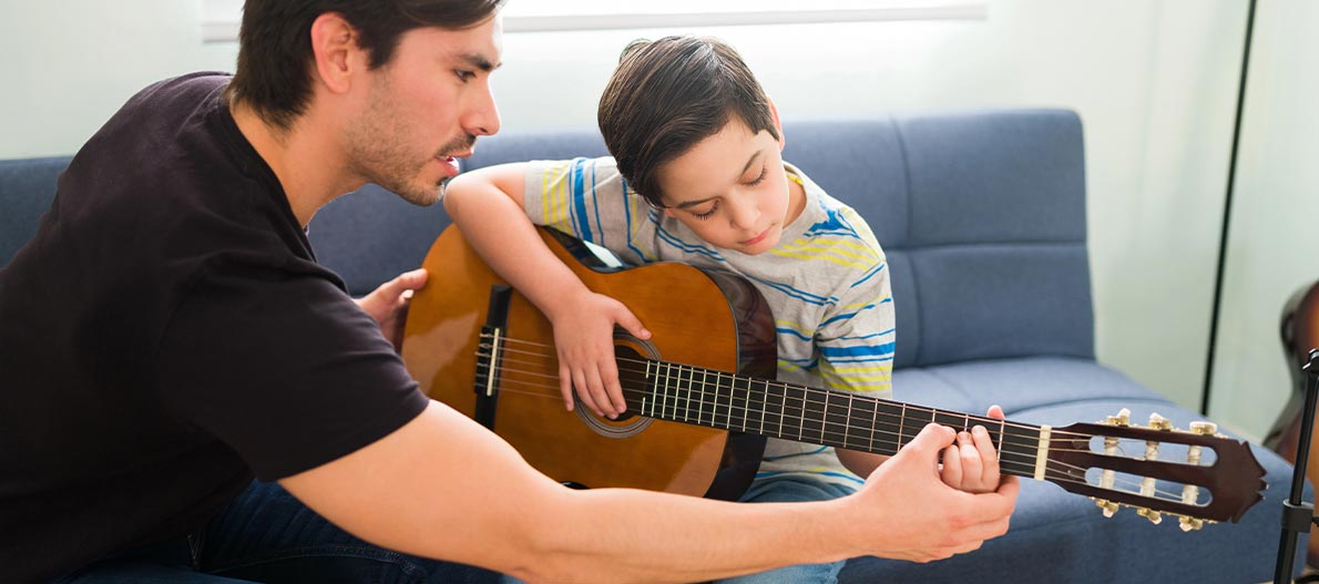 Guitar teacher and a boy having lesson