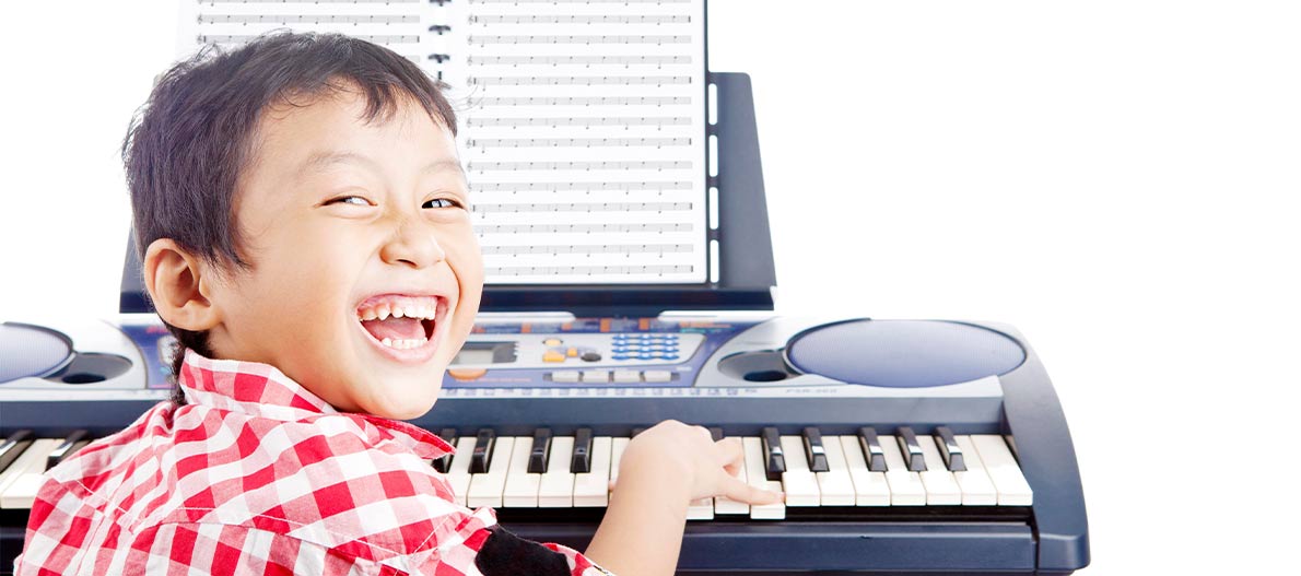 Happy boy playing the keyboard