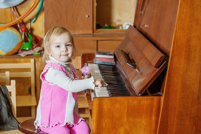 Toddler girl hands on piano keys