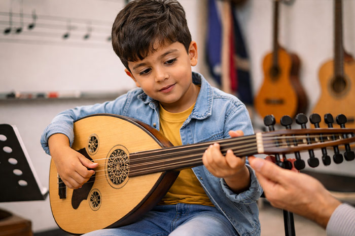 Young boy learning to play oud in music school