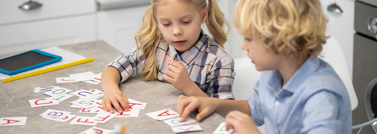 Two children playing alphabet cards together