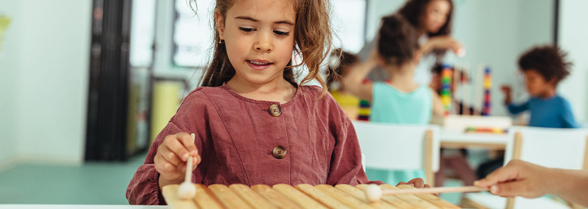 Girl playing xylophone in home