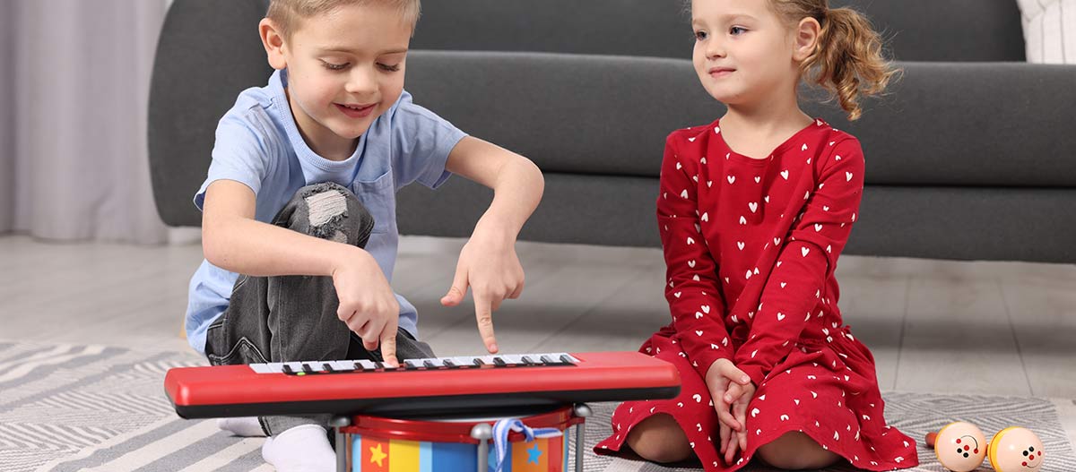 Children exploring keyboard and percussion instruments at home