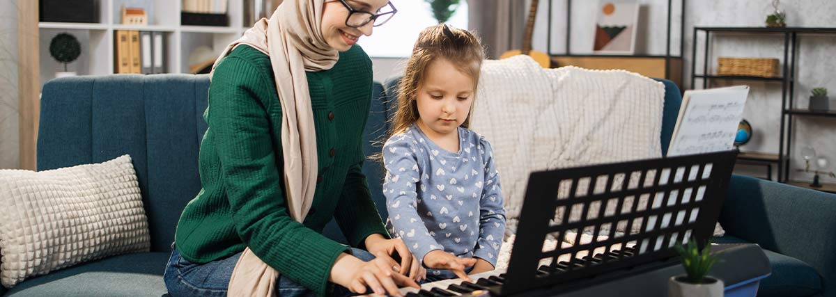 Lady and girl playing keyboard in the room