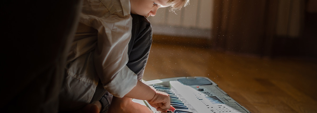 Little boy playing keyboard on floor