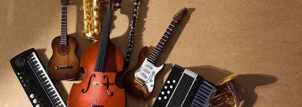 Selection of musical instruments for children including guitar, violin, saxophone and keyboard
