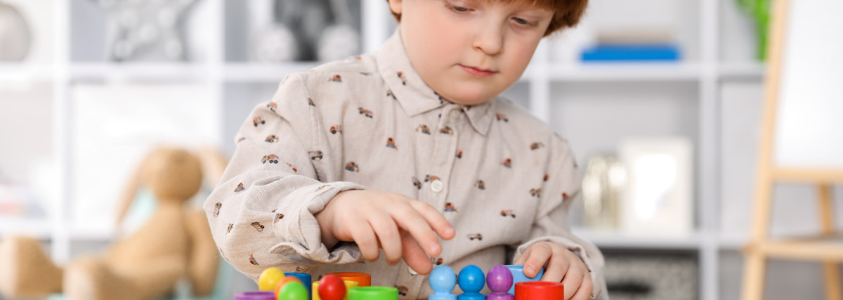 Child using colourful learning pieces to practise problem solving, concentration and flexible thinking