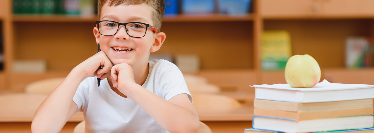 Happy schoolchild studying at a desk