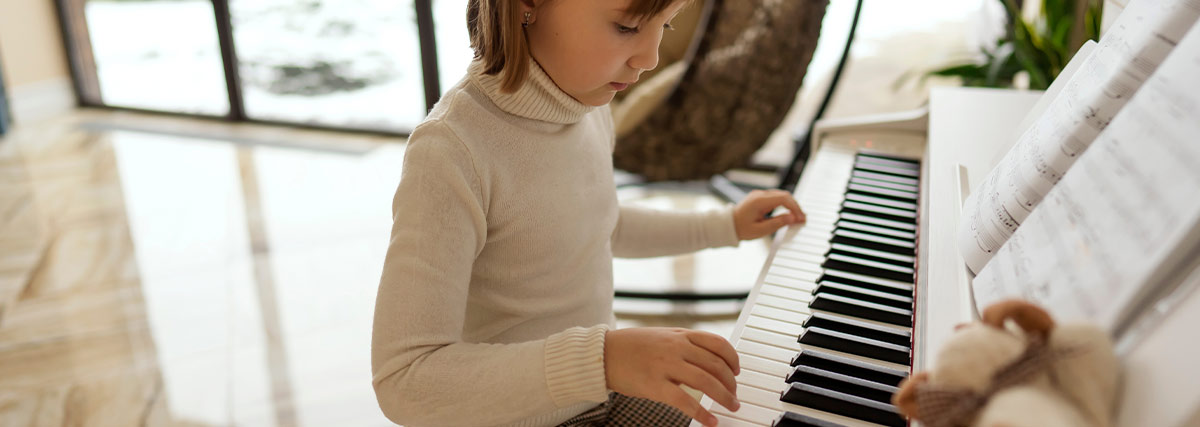 Young child practising piano and reading sheet music