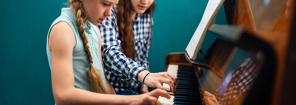 Young piano student learning from mistakes with guidance